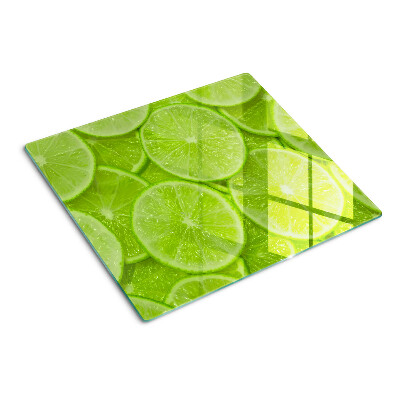 Steklena podloga za rezanje Rezine limete na zelenem ozadju