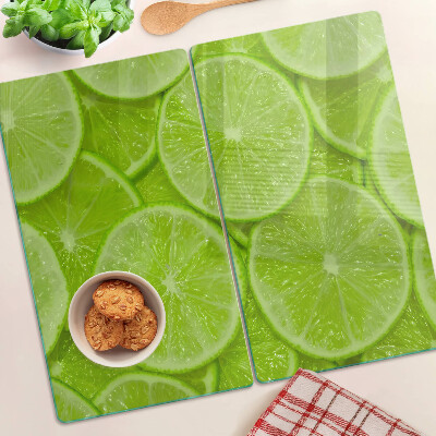 Steklena podloga za rezanje Rezine limete na zelenem ozadju