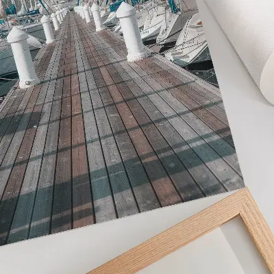 Stenski plakat z motivom morskega pomola z jahtami pod modrim nebom simetrične kompozicije