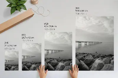Eleganten plakat za dnevno sobo mirna pokrajina z mostom, skalnato plažo in sivim nebom