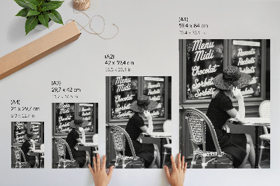 Premium stenski plakat Ženska s klobukom za mizo v kavarni