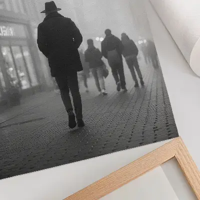 Plakat figura v klobuku z dežniki v megli