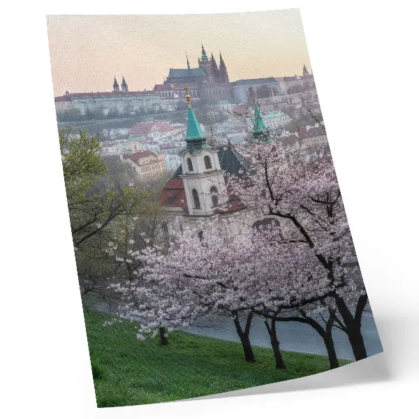 Plakat mesto spomladi s cvetočimi drevesi in cerkvenimi zvoniki