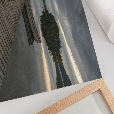 Plakat na platnu jezero s čolnom v gozdu pod oblaki za pomirjujoče vzdušje
