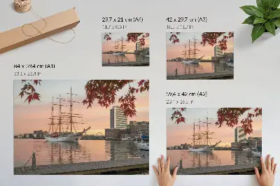 Plakat na platnu jadrnica ob sončnem zahodu v mirnem mestnem panoramskem razgledu