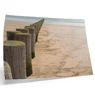 Plakat na platnu z motivom lesenih kolov na plaži ob morju v naravi